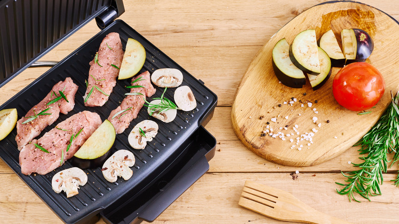 Panini press with meat and veggies inside