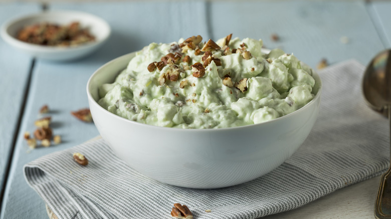 A watergate salad topped with and surrounded by crushed pistachios