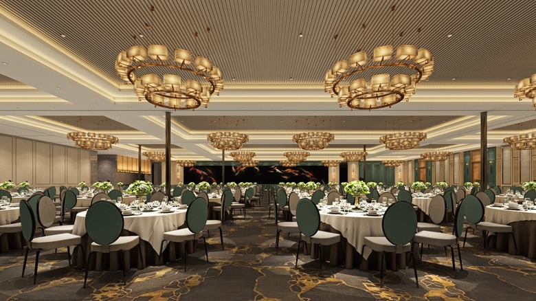 Massive, ornate dining room in H.L. Peninsula Castro Valley, with gray-gold carpeting and chandeliers.