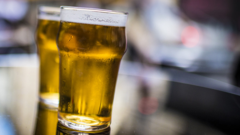 Two pint glasses of light-colored beer