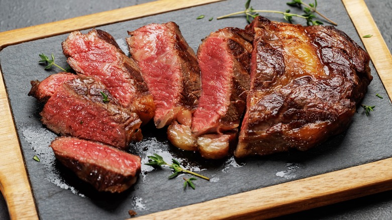 Sliced rare steak on board