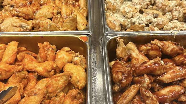 Numerous chicken wings in a buffet setting.