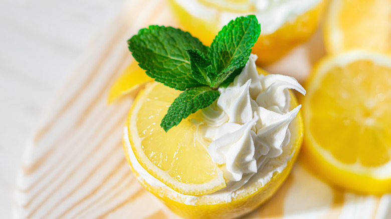 Lemon cup topped with mint, frosting, and lemon slice