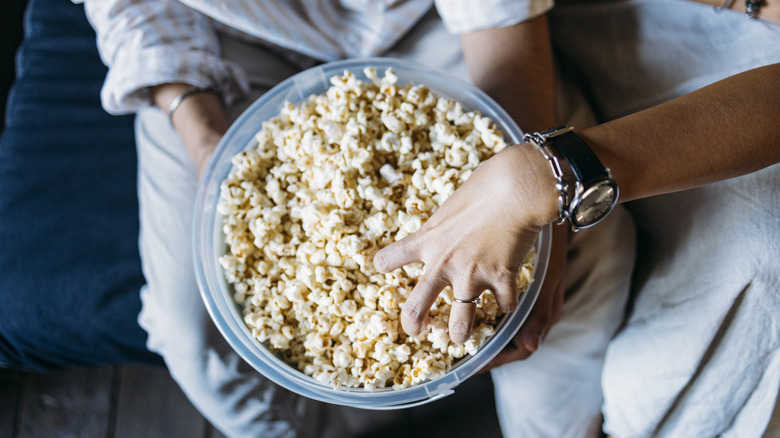 Hand in bowl of popcorn