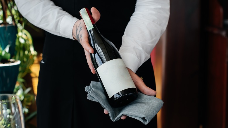 Waiter offering bottle of wine