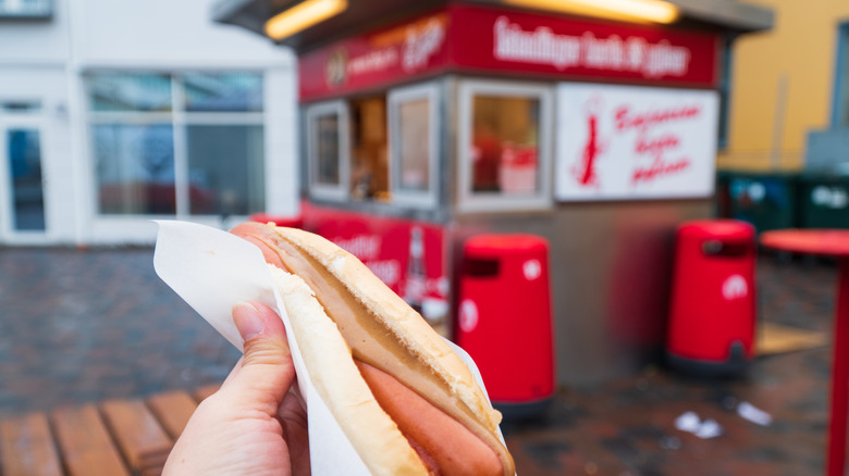 Icelandic hot dog with mustard in front of store