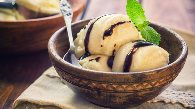 Ice cream in a bowl with chocolate drizzle and mint
