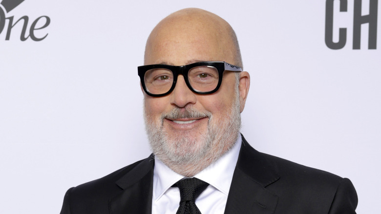 Andrew Zimmern faintly smiling in black-rim glasses and tuxedo