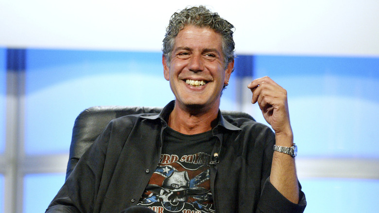 bourdain sitting in a chair smiling