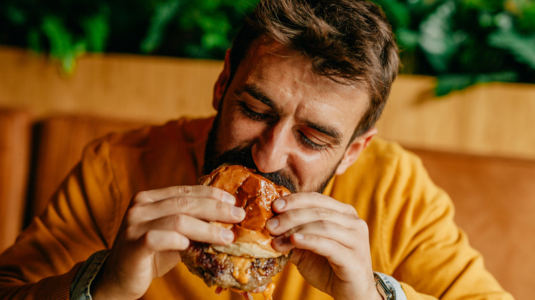 man eating cheeseburger