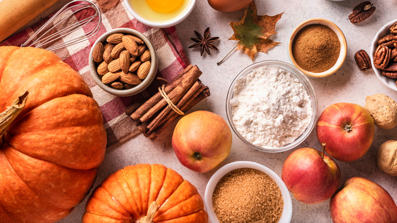 Ingredients laid out for fall baking that include pumpkin, apple, ginger, cinnamon