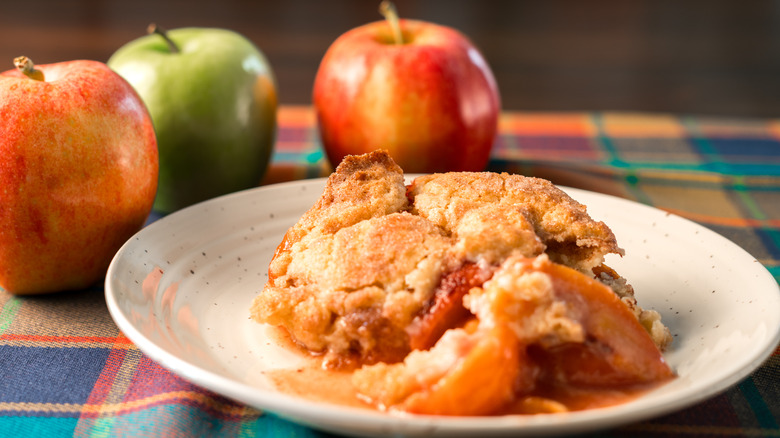 Plated apple cobbler alongside apples.