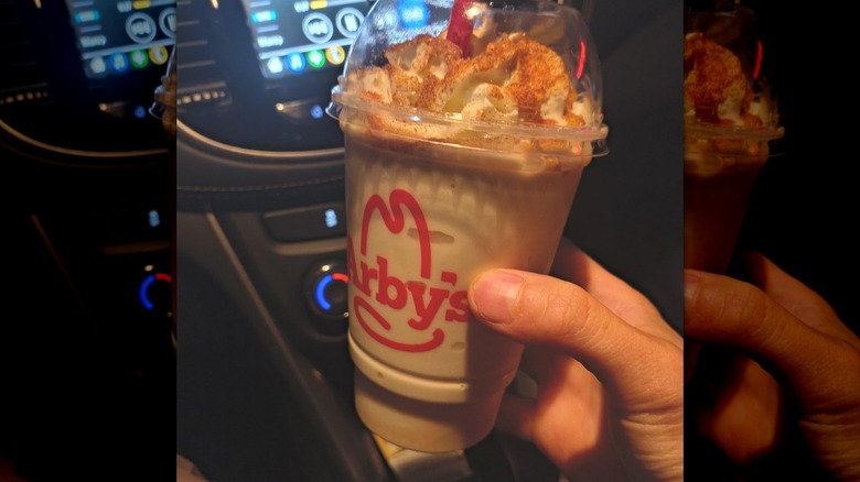 Hand holding a milkshake from Arby's
