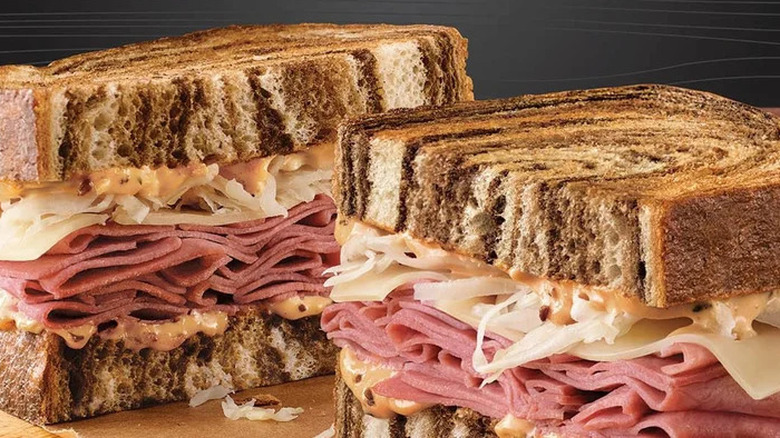 Arby's reuben sandwich on marble rye bread with corned beef, sauerkraut, and thousand island dressing