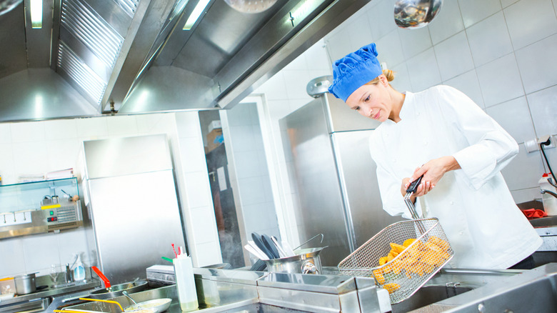 restaurant worker frying food in kitchen