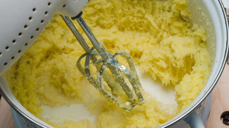 mashed potatoes being mixed with electric mixer