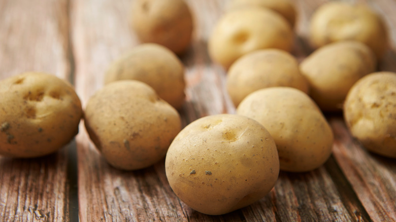 raw potatoes on wooden table