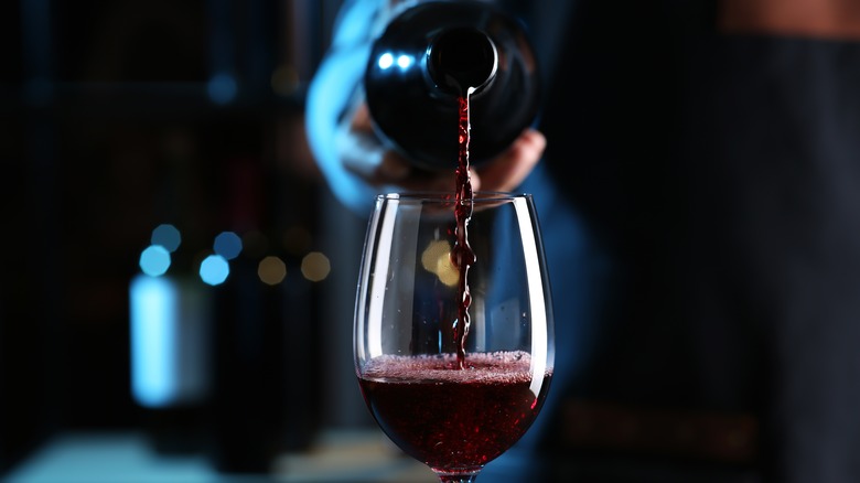 Dark red wine being poured into a glass