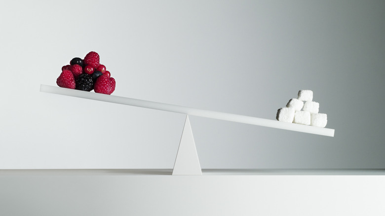 sugar cubes and fruit on a balancing scale