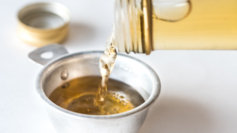 White wine vinegar pouring into cup