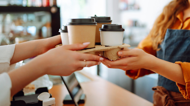 Barista passing coffee drinks to customer