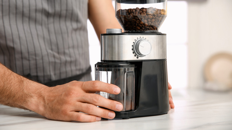 Hand holding a coffee grinder