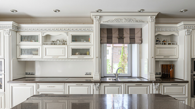 Outdated kitchen with ornate woodwork, hardware, and moulding