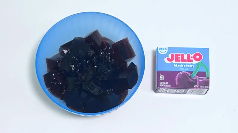 Bowl of black cherry Jell-O next to its box