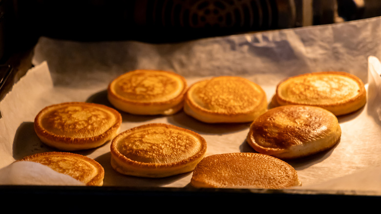 Small golden brown pancakes on a baking sheet.
