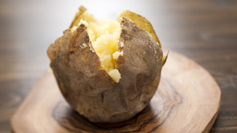 Plain baked potato on wooden board