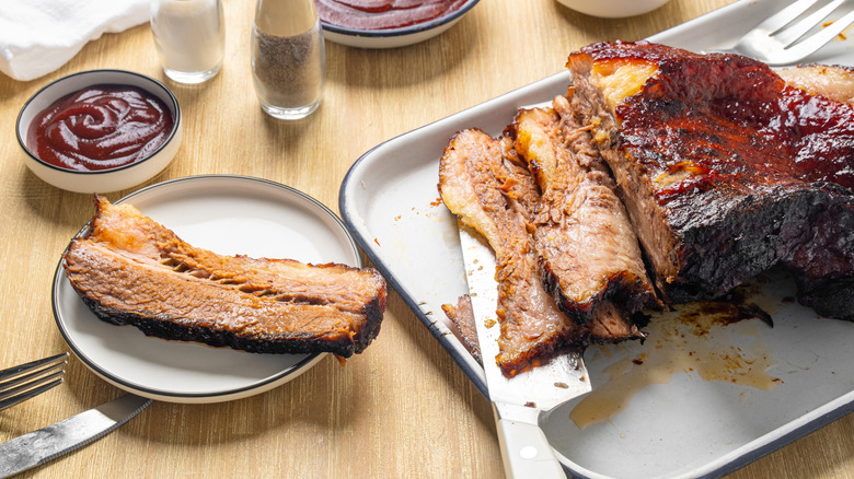 Dish of barbecue brisket with bowl of barbecue sauce