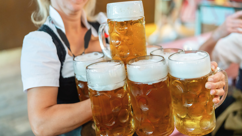 Server laden with giant glass beer steins at Munich's Oktoberfest celebration