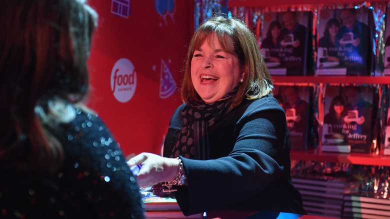 Ina Garten signing cookbooks at an event with Food Network