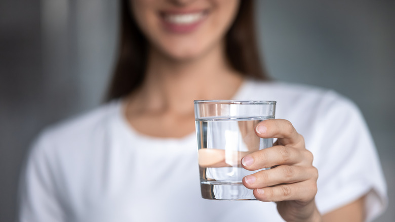 Woman holding glass of water
