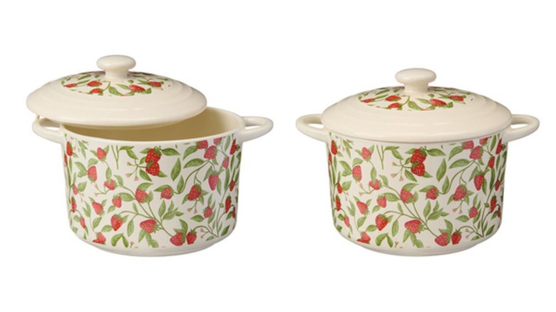 Two round, cream-colored mini baking pans with lids, decorated with a strawberry print
