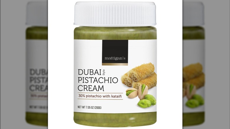 A clear, white-labeled jar of Mattigan's Dubai Style Pistachio Cream Spread, showing the green spread inside