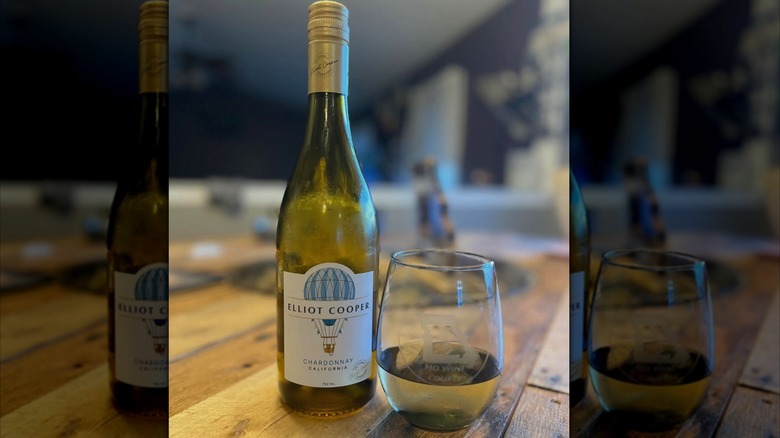 Bottle and glass of chardonnay on a wooden table