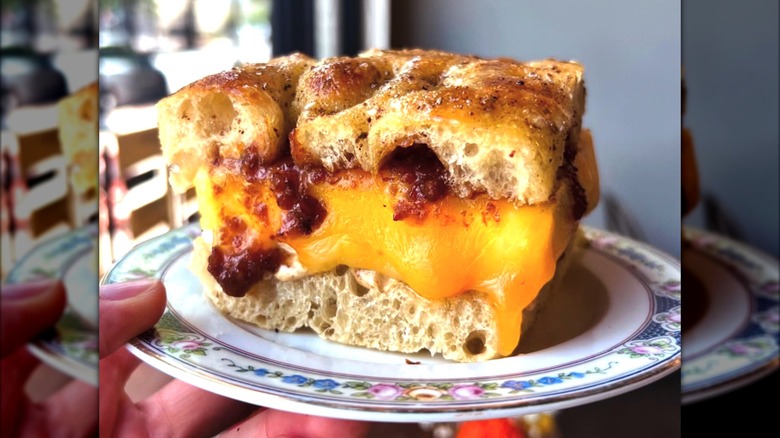 Cheesy sandwich on focaccia bread on decorative plate