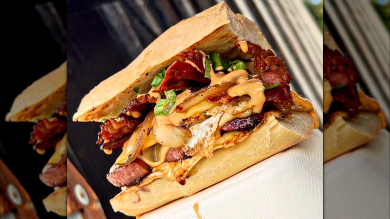 Egg, meat, and sauce stacked on sandwich