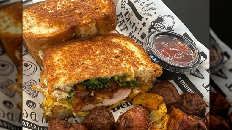 Chicken and egg sandwich on toasted bread with ketchup side