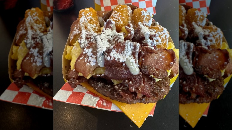 Sandwich stuffed with meat, eggs, and tater tots