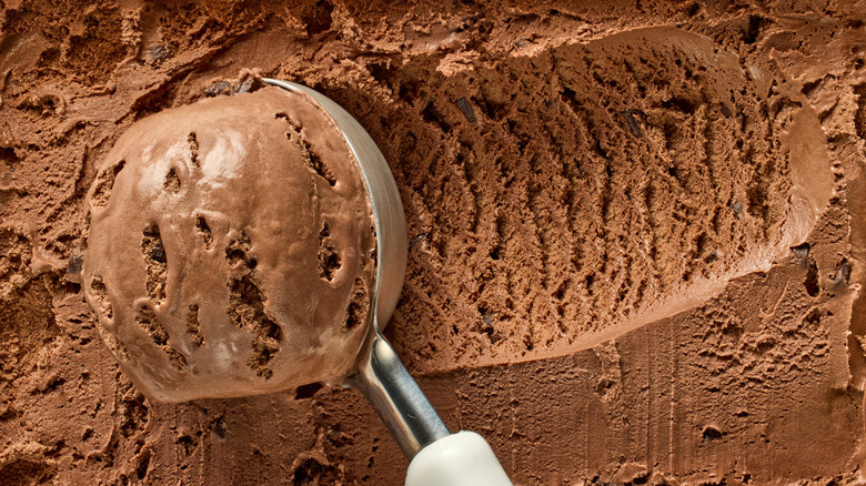 chocolate ice cream being scooped out of container