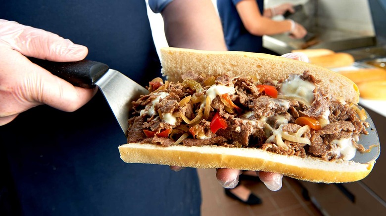 A person holding a cheesesteak from Jersey Mike's