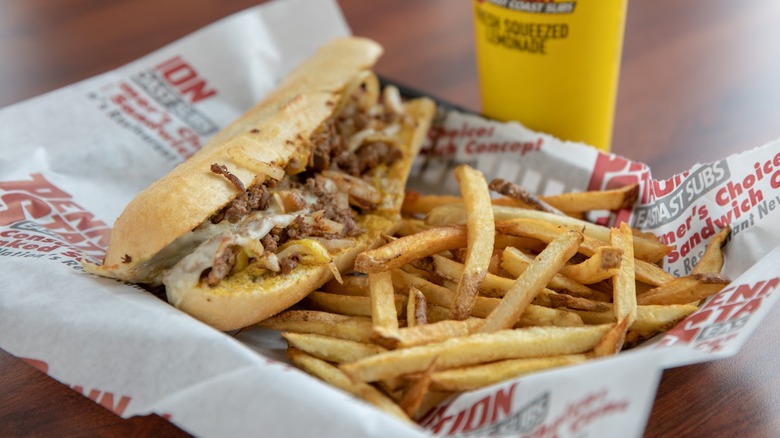 A cheesesteak and fries from Penn Station in a basket lined with paper