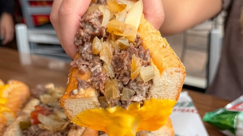 A person holding a cheesesteak from Philly's Best