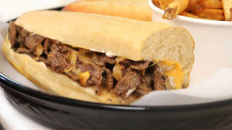 A cheesesteak from Steak Escape in a black plate