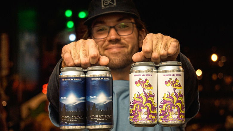 man holding Four Quarters beers