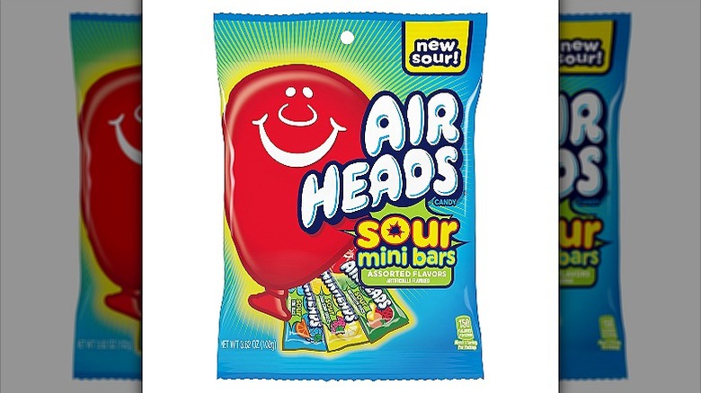 A packet of air heads sour mini bars with a red smiley on the left