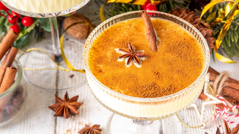 A closeup of a brandy alexander cocktail in a coupe glass covered in cinnamon