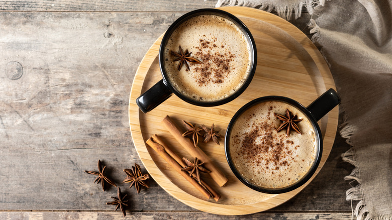 Two cups of chai surrounded by spices